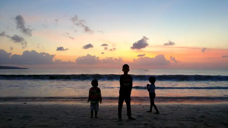 Jimbaran Bali with kids at sunset on a calm beach