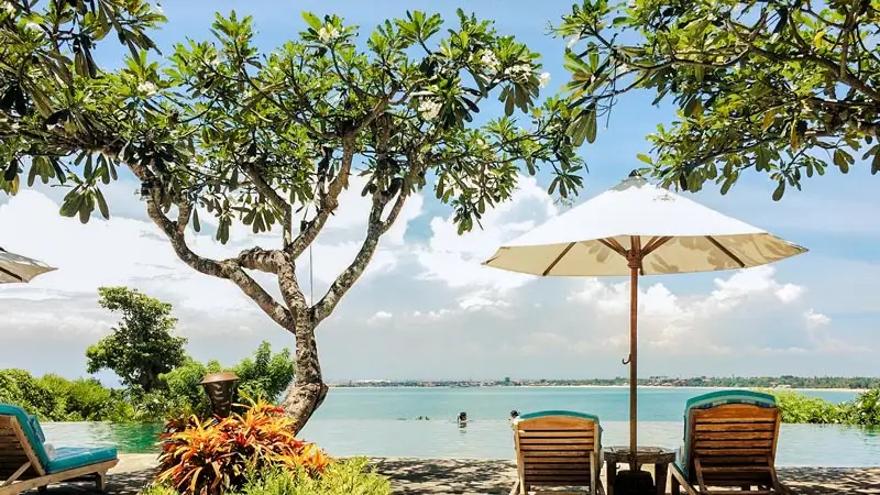 Infinity pool and sun loungers at a family resort in Jimbaran Bali
