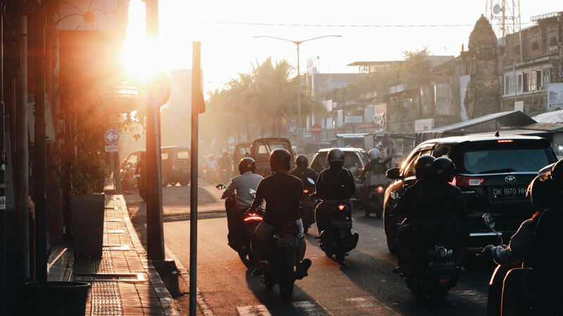 Motorbikes and cars in busy evening traffic