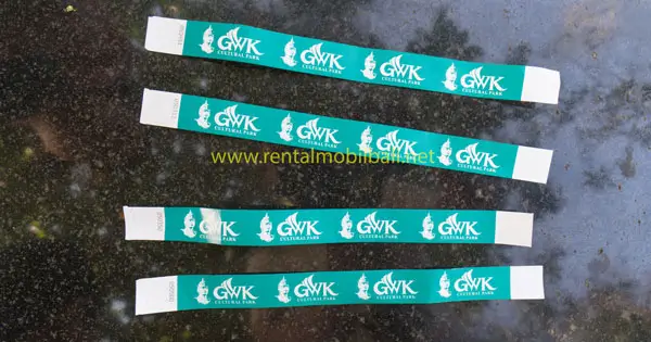 Four green GWK Bali Cultural Park paper wristband tickets on dark surface