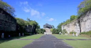 Daytime view of Lotus Pond GWK Bali with limestone walls and Garuda statue in the distance