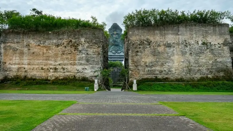 Stone walkway at Lotus Pond GWK framed by limestone cliffs and Garuda statue