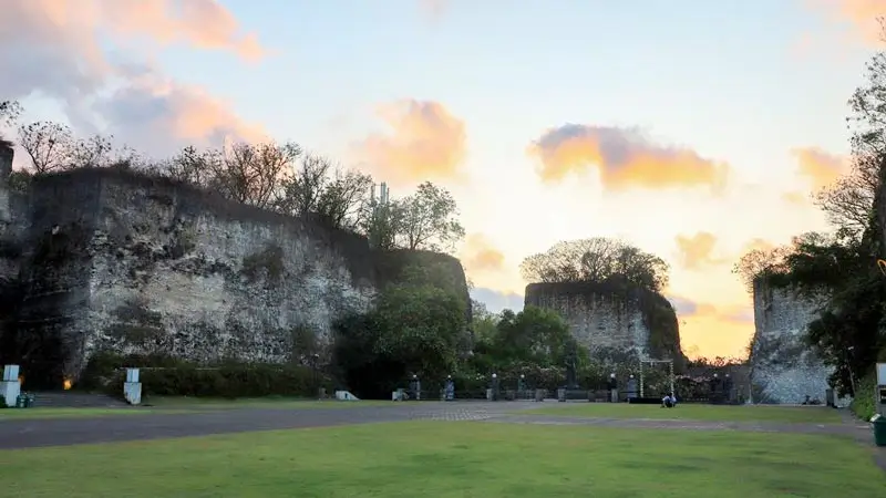 Wide view of Lotus Pond GWK plaza with grass and limestone cliffs at sunset