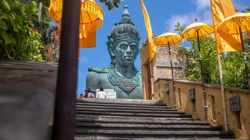 Stairs up to the Plaza Wisnu statue at GWK Cultural Park Bali with yellow umbrellas