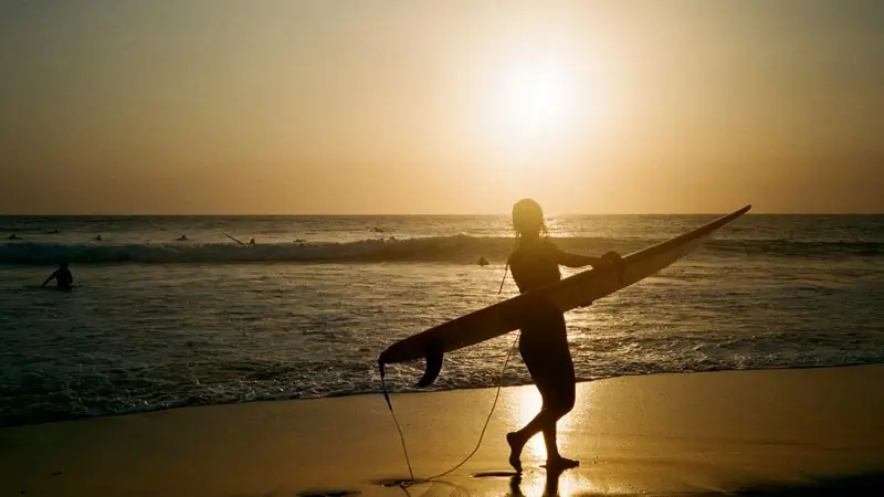 Surfer silhouette at Berawa Beach during sunset