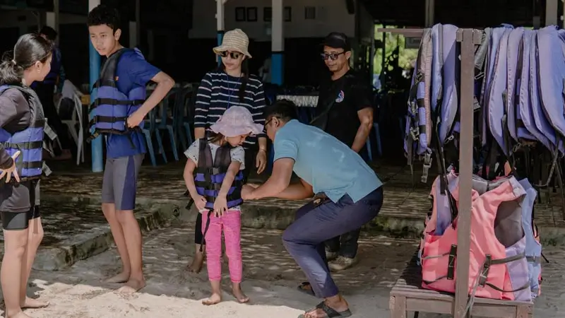 Staff fitting a life jacket on a child before the activity