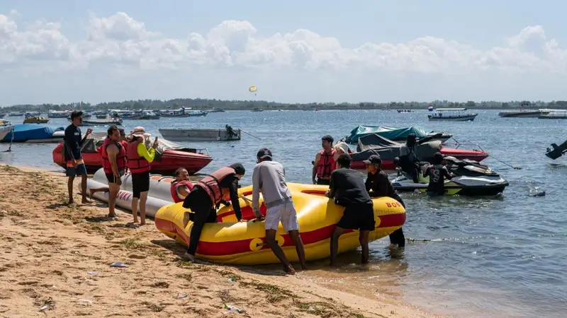 Crew preparing the towable donut tube at the shoreline