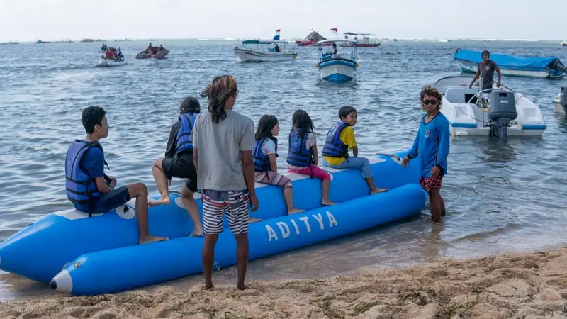 Family boarding a banana boat at the shoreline