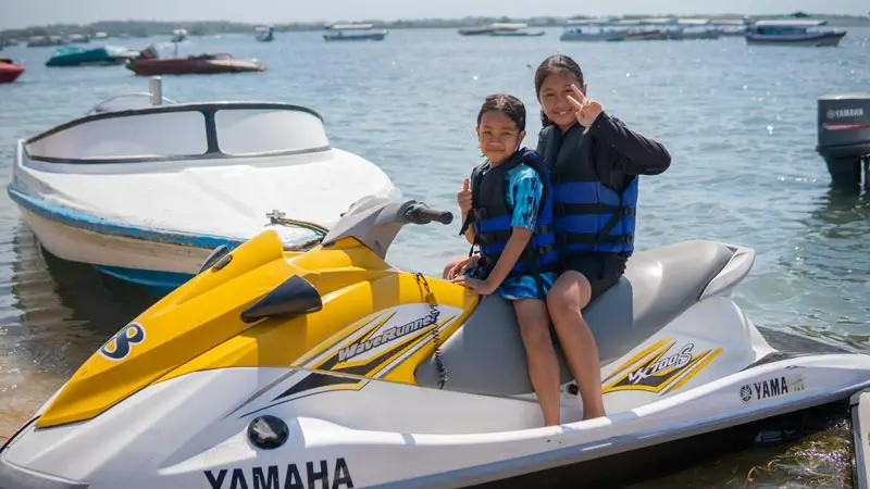 Children sitting on a jet ski before the ride (life jackets)