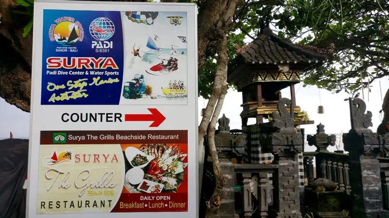 Surya PADI Dive Center & Water Sports sign with arrow to counter, Sanur