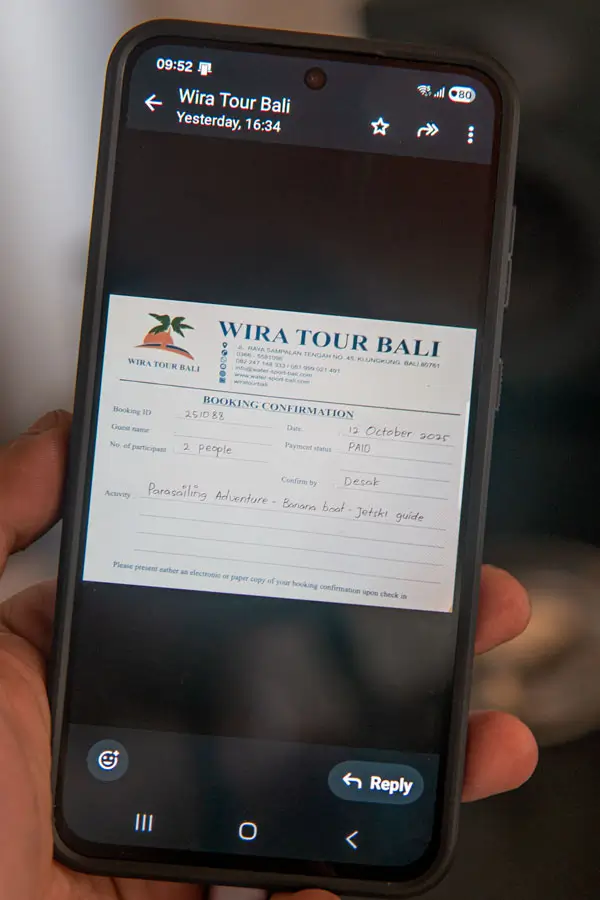 Wira Tour Bali booking confirmation voucher shown on a phone screen (WhatsApp)