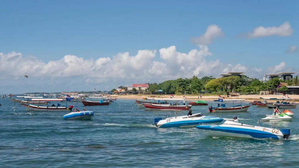 Bali water sports at Tanjung Benoa with boats, banana boat, and jet ski on the sea