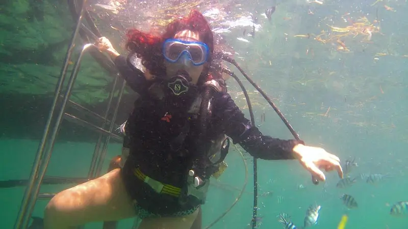 Beginner diver near a boat ladder during a first scuba experience in Bali