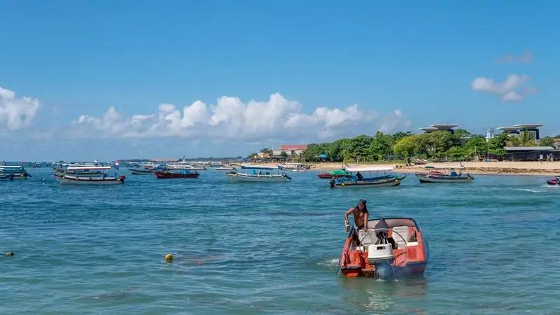 Water activities in Bali sea conditions nearshore at Tanjung Benoa, with boats and light chop