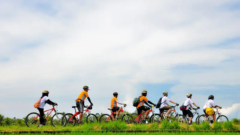 Travelers cycling through a rural route in Bali