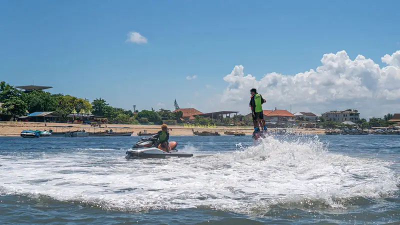 Flyboard rider near the water surface in Tanjung Benoa with support jet ski