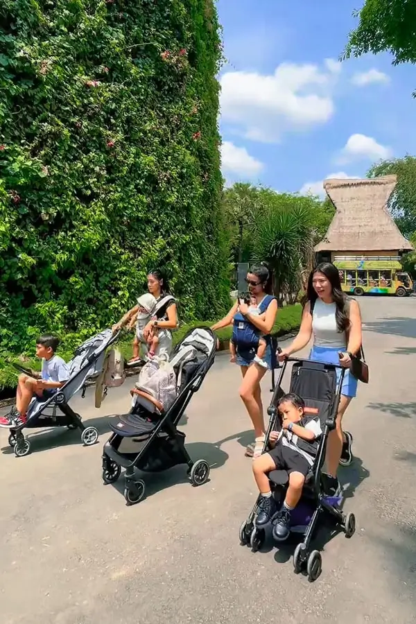 Families using strollers on a wide visitor path at Bali Zoo