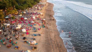 Aerial view of Kuta Beach Bali with waves, loungers, and visitors