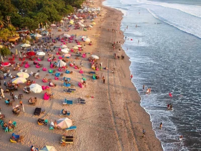 Aerial view of Kuta Beach Bali with waves, loungers, and visitors