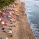 Aerial view of Kuta Beach Bali with waves, loungers, and visitors