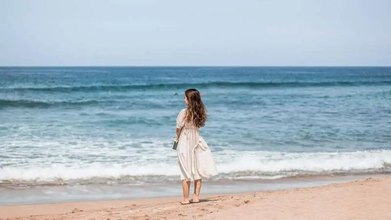 Visitors watching the ocean on the shoreline at Kuta Beach Bali