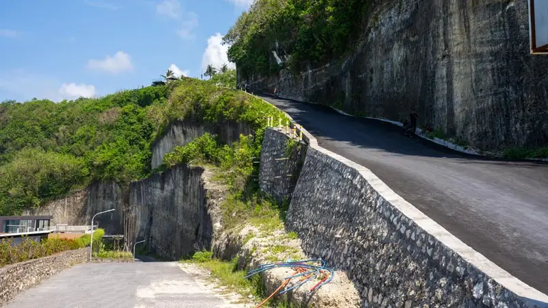 Steep road cut through limestone cliffs in Uluwatu