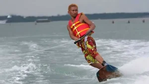 Wakeboarder wearing a life jacket balancing on the water at Tanjung Benoa.